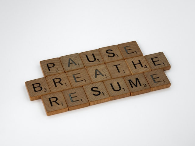 Scrabblesteine legen in drei Zeielen die Worte "pause", breathe" und "resume"