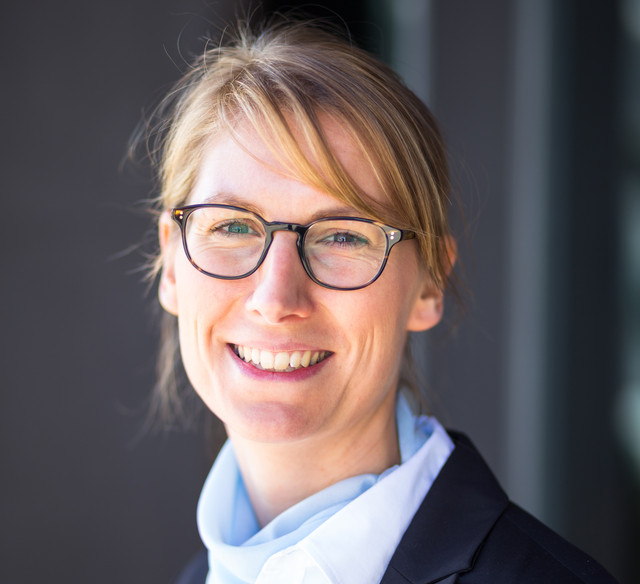 Porträtbild der Impulsgeberin eines Praxisforums vor grauem Hintergrund